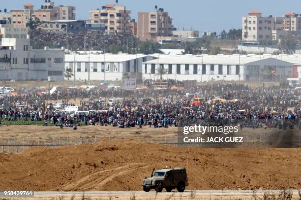 Picture taken on May 14, 2018 from the southern Israeli kibbutz of Nahal Oz across the border with the Gaza Strip shows Palestinian protestors...