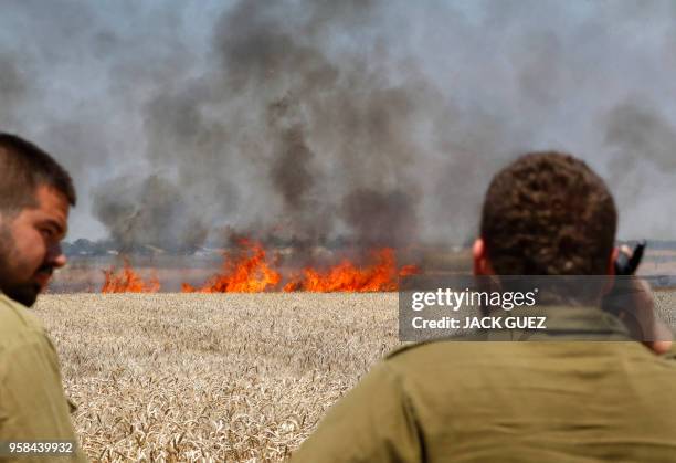 Picture taken on May 14, 2018 shows fire burning in a scorched wheat field near the Kibbutz of Nahal Oz, along the border with the Gaza Strip, caused...