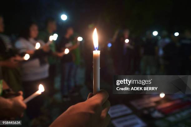 Indonesian people take part in a candlelight vigil in support of the victims and their relatives following a series of bomb attacks in Surabaya, in...