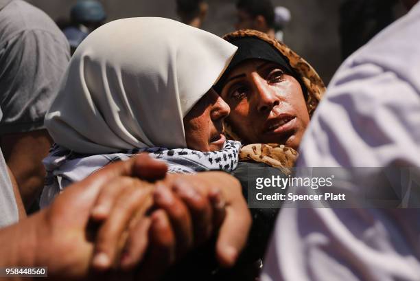 Wounded Palestinian women is carried from the border fence with Israel as mass demonstrations at the fence continue on May 14, 2018 in Gaza City,...
