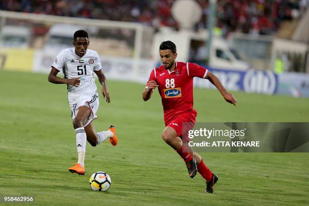 Al-Jazeera club player Khalfa Mubarak and Iranian Perspolis FC club player Siamak Nemati vie for the ball during their AFC Champions League football...