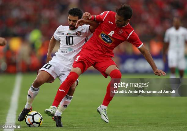 Mbark Boussoufa of Al Jazira and Ahmad Noorollahi in action during AFC Champions League match between Persepolis and Al Jazira at Azadi Stadium on...