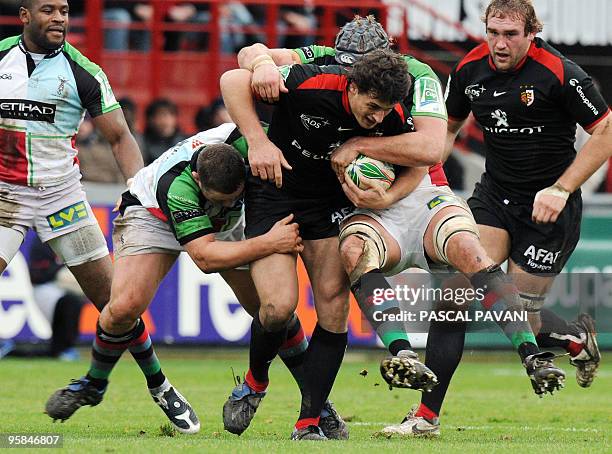 Toulouse's centre Yannick Jauzion collapses with London Harlequins's prop John Andress and lock James Percival during their European Cup rugby union...