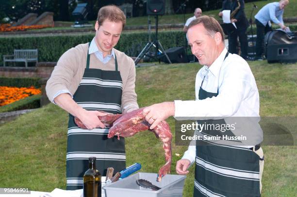 Prince William and John Key, Prime Minister of New Zealand prepare meat at a barbecue at Premiere House on the second day of his visit to New Zealand...