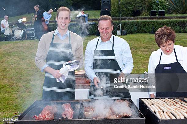 Prince William and John Key, Prime Minister of New Zealand prepare meat at a barbecue at Premiere House on the second day of his visit to New Zealand...