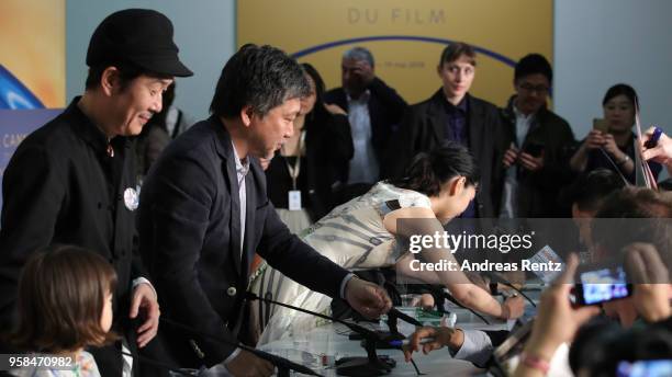 Hirokazu Koreeda Lily Franky and Sakura Ando sign autographs during the press conference for "Shoplifters " during the 71st annual Cannes Film...