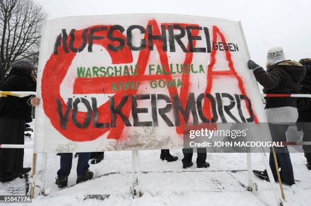 Demonstrators display a banner reading "Outcry against genocide" during an anti-Israel protest between the chancellery and the Reichstag building in...