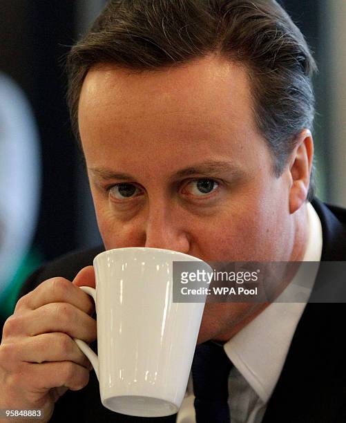 David Cameron, the Conservative Party leader, drinks tea as he talks with teachers and staff during a visit at the Walworth Academy, January 18, 2010...
