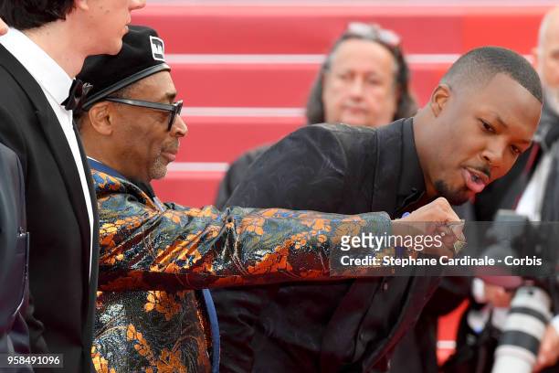Actor Corey Hawkins looks at the hands of director Spike Lee wearing knuckle rings with love and hate on them as he attends the screening of...