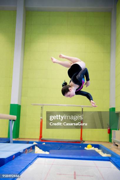 jong meisje atleet met plezier beoefenen op trampoline - achterwaartse salto stockfoto's en -beelden