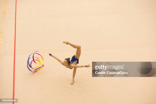 teenage rhythmic gymnastics athlete practicing with ribbon - rhythmic gymnastics stock pictures, royalty-free photos & images
