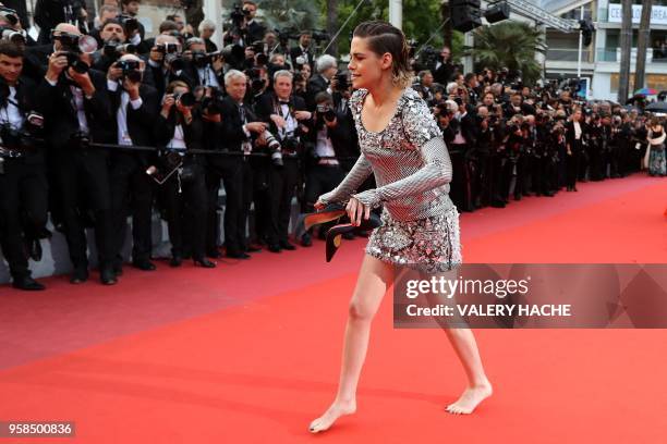Actress and member of the Feature Film Jury Kristen Stewart walks barefoot on the red carpet after she removed her shoes as she arrives on May 14,...