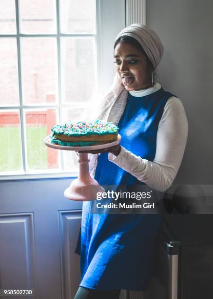 a muslim girl in hijab is tempted to eat birthday cake - muslimgirlcollection ストックフォトと画像