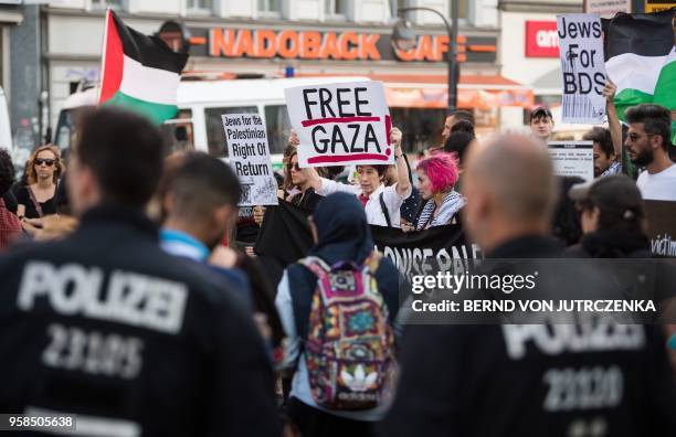 People wave Palestinian flags as they protest in in Berlin on May 14, 2018. - The United States moved its embassy in Israel to Jerusalem after months...