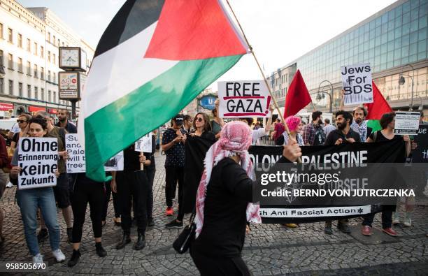 People wave Palestinian flags as they protest in in Berlin on May 14, 2018. - The United States moved its embassy in Israel to Jerusalem after months...