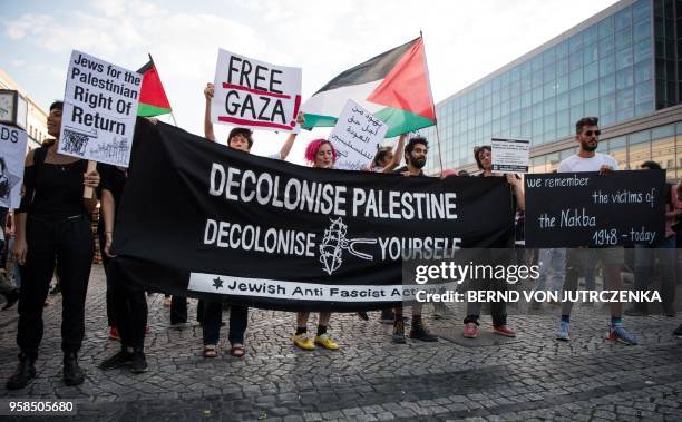 People wave Palestinian flags as they protest in in Berlin on May 14, 2018. - The United States moved its embassy in Israel to Jerusalem after months...