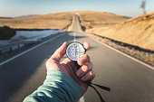 Compass in Hand mountain road background .Vintage Tone