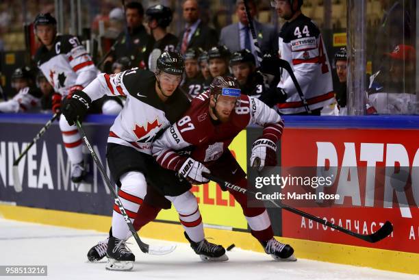Tyson Jost of Canada and Gints Meija of Latvia battle for the puck during the 2018 IIHF Ice Hockey World Championship Group B game between Canada and...