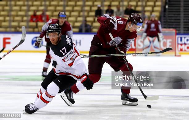 Jaden Schwartz of Canada and Rodrigo Abols of Latvia battle for the puck during the 2018 IIHF Ice Hockey World Championship Group B game between...