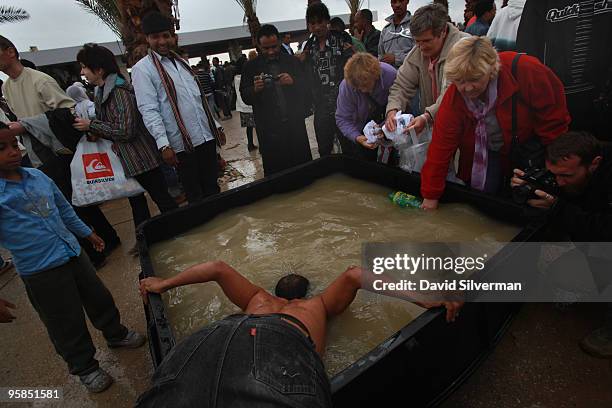 Christian baptizes himself in a tub of water drawn from the River Jordan on January 18, 2010 at the Qasr al Yahud baptism site near Jericho in the...