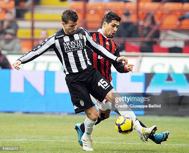 Brandao of Siena and Marco Borriello of Milan in action during the Serie A match between Milan and Siena at Stadio Giuseppe Meazza on January 17,...