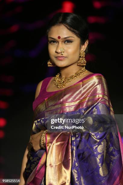 Indian woman wearing an elegant and ornate Kanchipuram saree during a South Indian fashion show held in Scarborough, Ontario, Canada.