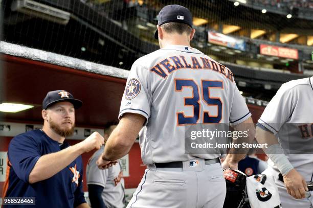 Justin Verlander of the Houston Astros is fist bumped by Chris Devenski when entering the dugout for the MLB game against the Arizona Diamondbacks at...