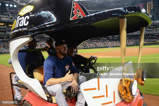 Chris Devenski, Collin McHugh and Brad Peacock of the Houston Astros take a ride to the bullpen in the bullpen cart prior to the MLB game between the...
