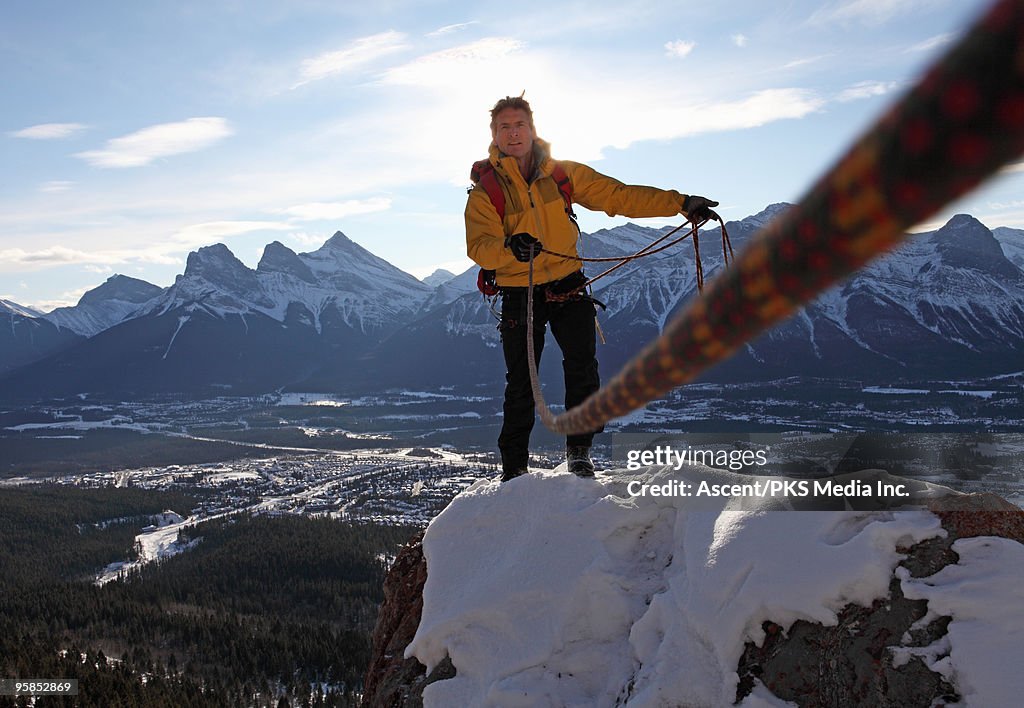 Mountaineer takes in slack rope to partner, ridge 