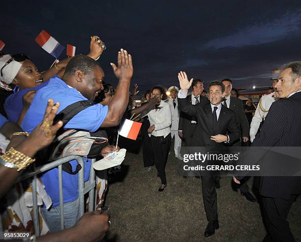 French President Nicolas Sarkozy waves to supporters upon his arrival at Pierrefonds airport in Saint-Pierre de La Reunion island on January 18 as...