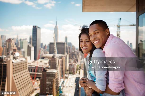business couple embracing in hotel balcony - landmark hotel stock pictures, royalty-free photos & images