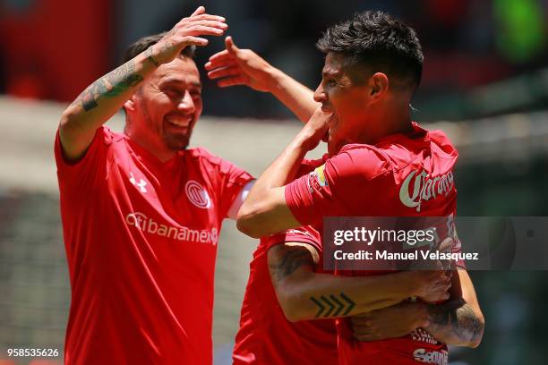 Pablo Barrientos of Toluca celebrates with teammates Rodrigo Salinas and Rubens Sambueza after scoring the third goal of his team during the...