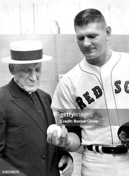 Boston Red Sox relief pitcher Dick Radatz shows Cardinal Richard Cushing how he grips the baseball in Boston on July 25, 1963.
