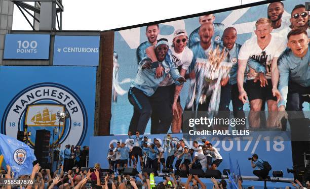 Manchester City players hold the trophy as they attend an event for fans with members of the Manchester City football team following an open-top bus...