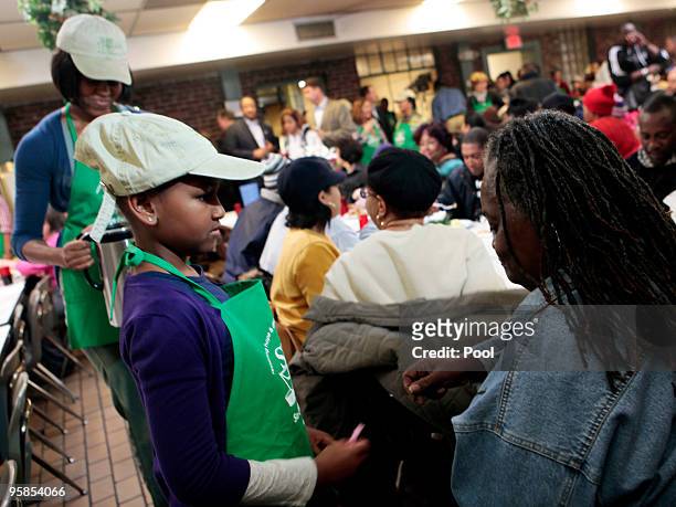 First lady Michelle Obama and daughter Sasha honor the Martin Luther King legacy by serving meals to the needy at a facility January 18, 2010 in...