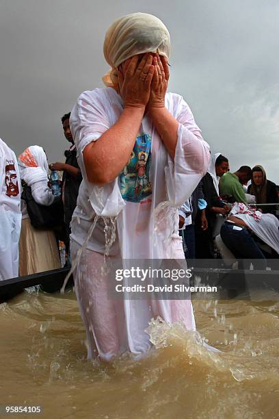 Christian pilgrim baptizes herself in a tub of water drawn from the River Jordan on January 18, 2010 at the Qasr al Yahud baptism site near Jericho...