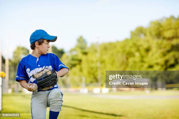 boy playing baseball on field - young baseball pitcher stock pictures, royalty-free photos & images