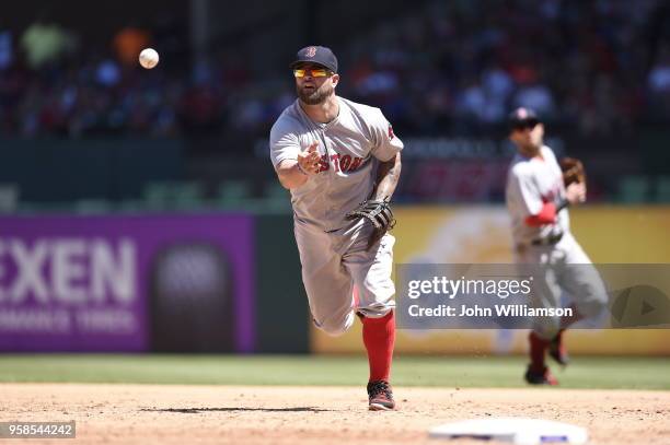 First baseman Mike Napoli of the Boston Red Sox tosses the ball underhanded to the pitcher covering first base to end the third inning of the game...