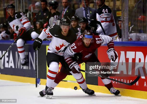 Tyson Jost of Canada and Gints Meija of Latvia battle for the puck during the 2018 IIHF Ice Hockey World Championship Group B game between Canada and...