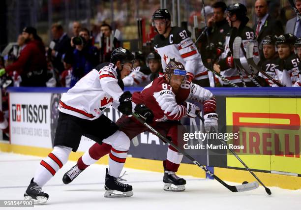 Tyson Jost of Canada and Gints Meija of Latvia battle for the puck during the 2018 IIHF Ice Hockey World Championship Group B game between Canada and...