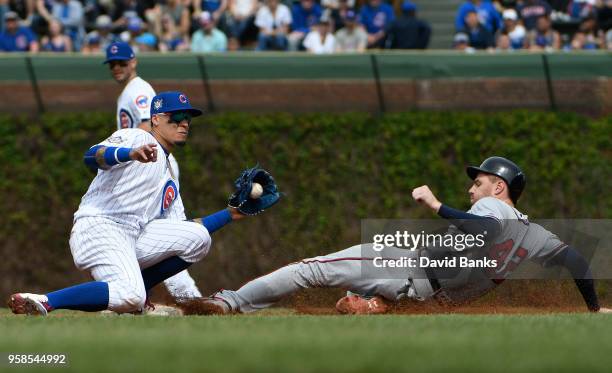 Freddie Freeman of the Atlanta Braves steals second base as Javier Baez of the Chicago Cubs makes a late tag during the sixth inning while wearing...