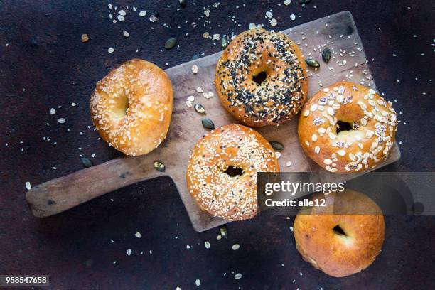 bagels en tabla de cortar - carbohidrato fotografías e imágenes de stock