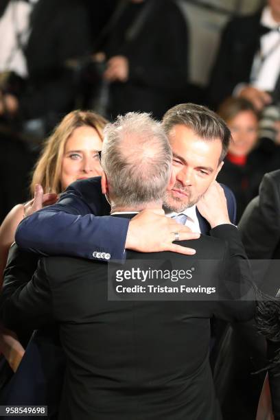 Clovis Cornillac hugs Cannes Film Festival Director Thierry Fremaux as he attends the screening of "The House That Jack Built" during the 71st annual...