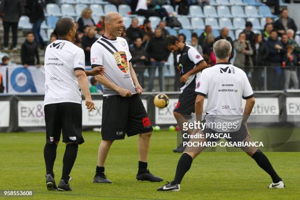 Real Madrid's French coach Zinedine Zidane laughs with France's coach Didier Deschamps during the warm-up before the charity match organized by...