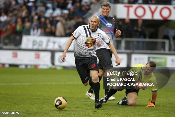 Real Madrid's French coach Zinedine Zidane vies with Pascal Olmeta during the charity match organized by French football player Pascal Olmeta for his...