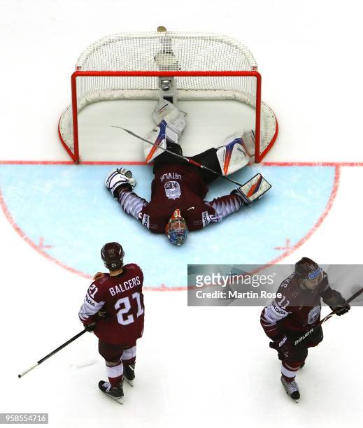 Kristers Gudlevskis, goaltender of Latvia lies dejected on the ice after losing against Canada during extra time during the 2018 IIHF Ice Hockey...