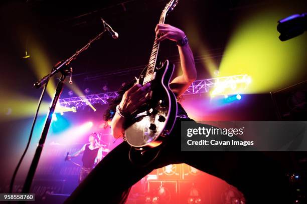 low angle view of man performing at concert - rockmuziek stockfoto's en -beelden
