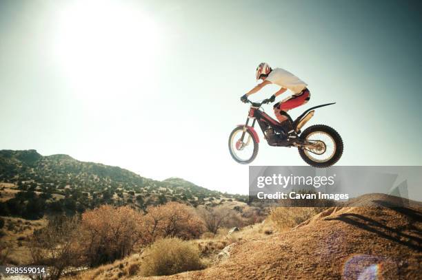 side view of man performing stunt with motorcycle against clear sky - motorcross stock pictures, royalty-free photos & images