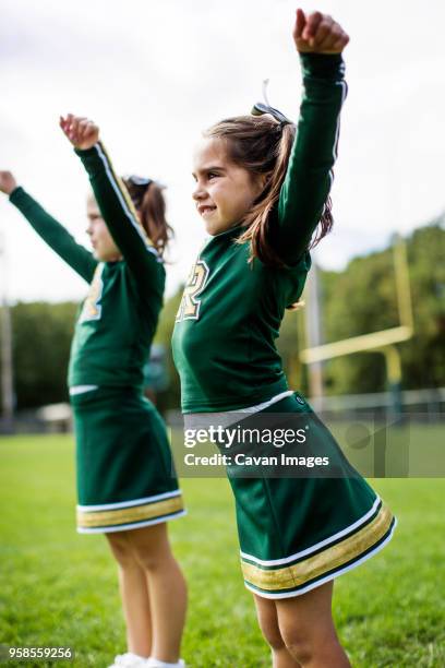 happy cheerleaders dancing on field against sky - cheerleader photos stock pictures, royalty-free photos & images