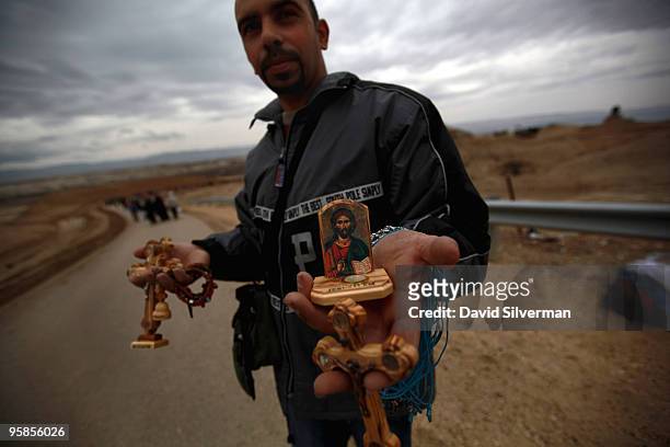 Palestinian vendor sells religious souvenirs during Epiphany celebrations on January 18, 2010 at the Qasr al Yahud baptism site near Jericho in the...